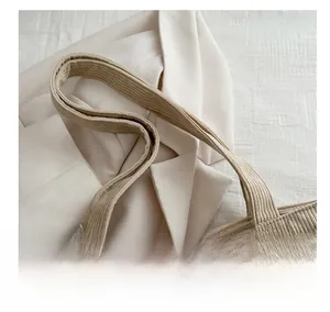 Detail of wide corduroy tote bag strap with reinforced stitching and soft fabric texture