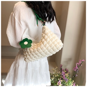 Detail of white bubble texture cloud bag with green flower charm and strap