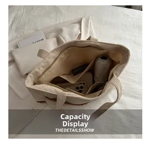 Capacity display showing large interior of beige corduroy tote bag with umbrella and phone