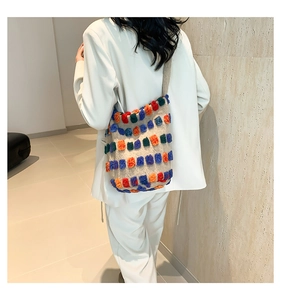 Detail of colorful plush texture and 3D knit patterns on beige shoulder bucket bag