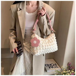Detailed macro view of white bubble texture fabric with pink straps and flower charm