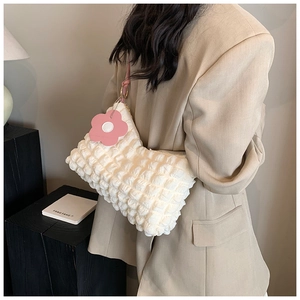 Detail of off-white bubble texture shoulder bag featuring a pink flower charm accessory