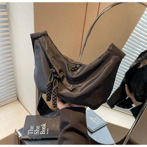 Détail du sac croissant en nylon noir avec tirette tressée et texture résistante à l'eau