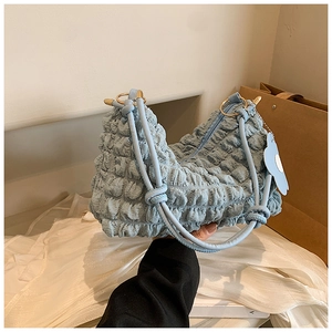 Detail of light blue cloud bag with textured bubble fabric and knotted shoulder strap