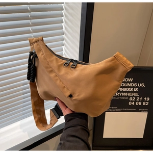 Détail du sac demi-lune en nylon kaki avec fermeture éclair et cordon tressé noir