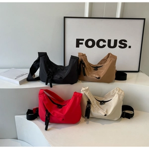 Minimalist nylon crescent bags in four colors with wide straps and textured woven pullers