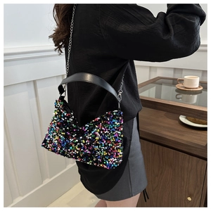 Detail showing a colorful sequin crossbody bag with silver chain strap worn by a model