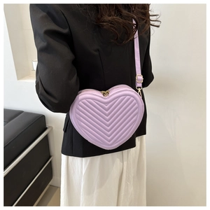 Detailed close-up of a heart-shaped lavender cross-body bag with V-quilted faux leather