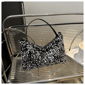 Detailed view of black sequin handbag with silver chain strap and top handle design