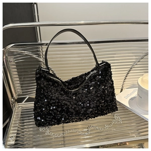 Detailed view of fashionable black sequined handbag with silver chain and leather handle