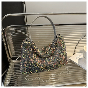 Detailed view of colorful sequin handbag with gray handle and silver chain strap