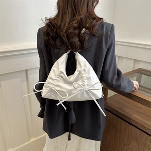 White pleated shoulder bag featuring elegant oversized bow accents for a stylish women's look