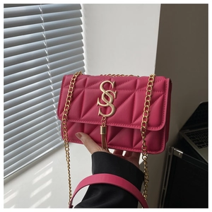 Détail du sac matelassé fuchsia avec logo S doré, franges et bandoulière chaîne