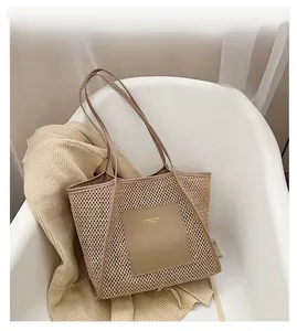 Detail of woven straw tote bag featuring khaki leather trim and fashion lettering