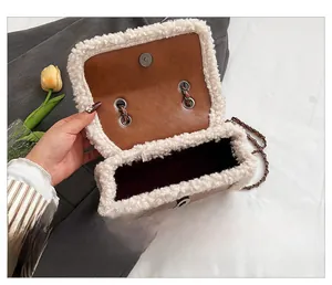 Detail view of the plush sherpa trim and magnetic buckle inside the brown flap bag