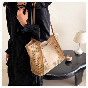 Elegante borsa tote in paglia con dettagli in pelle beige indossata da una modella in interno