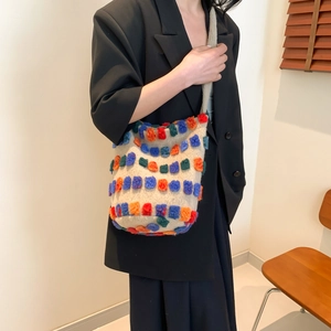Knitted tote bag with colorful 3D blocks on beige background shown on model