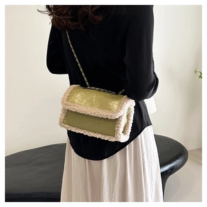 Detail of green glossy crossbody bag with white faux fur trim and gold chain strap