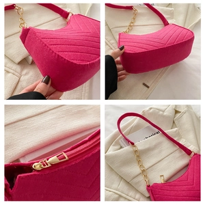 Macro detail of hot pink felt shoulder bag with V-quilting and gold chain strap