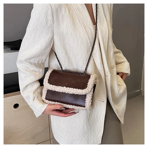 Detail of plush faux shearling trim and brown leather texture on luxury crossbody bag