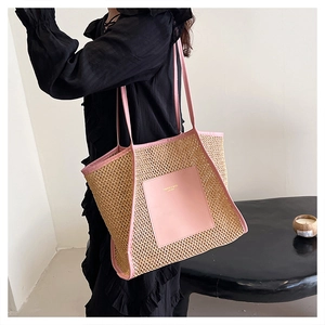 Dettaglio della tasca in pelle rosa su borsa in paglia intrecciata con scritte oro