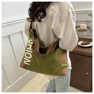 Olive green canvas tote bag with fashion lettering and leather trim detail