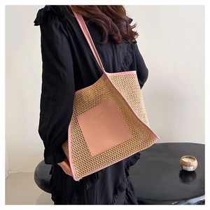 Dettaglio della borsa tote in paglia con finiture in pelle rosa indossata da una modella