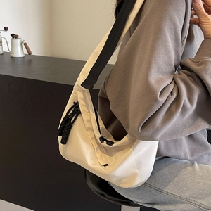 Sac bandoulière demi-lune beige minimaliste avec détail de fermeture éclair noire
