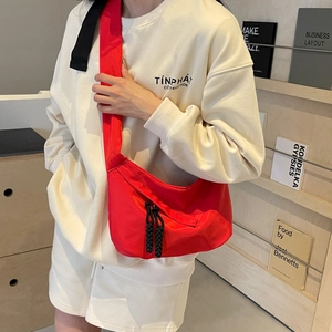 Sac bandoulière minimaliste en nylon rouge de forme demi-lune avec sangle réglable