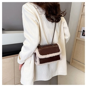 Close-up of retro brown leather crossbody bag with white shearling trim and chain strap