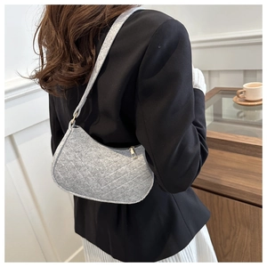 Detail of grey felt shoulder bag with V-shaped stitching and gold zipper from back view