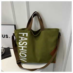 Detail of army green canvas tote with brown straps and white FASHION print text