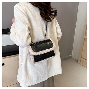 Detail showing retro black leather crossbody bag with white fleece trim on a model