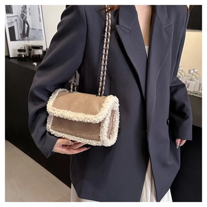 Detail of khaki leather shoulder bag with white faux fur trim and dual gold chain straps