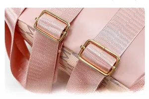 Detail of pink backpack featuring adjustable strap and gold hardware with logo pattern