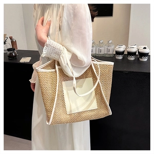 Dettaglio di una borsa tote intrecciata beige con finiture in pelle bianca in un caffè