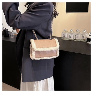 Close-up of small faux shearling trim crossbody bag with chain strap on a model