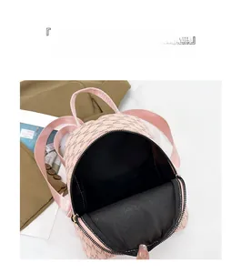 Top view of pink mini backpack with letter pattern showing black interior compartment