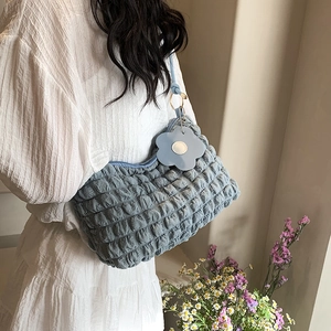 Blue bubble texture shoulder bag with floral charm and gold metal rings on a model