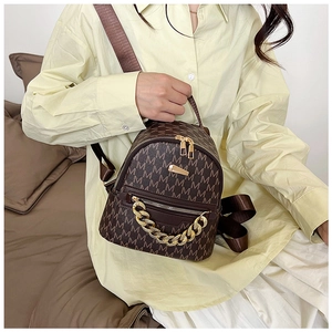 Detail of vintage brown mini backpack with M-pattern print and chunky gold chain