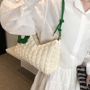 White popcorn textured shoulder bag with green knotted strap and floral charm