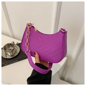 Detail of purple crescent shoulder bag with V-shaped quilting and gold chain strap