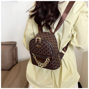 Close-up of vintage brown monogram mini backpack with golden chain and metal logo detail