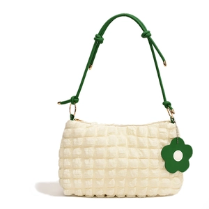 Chic off-white quilted bubble tote bag with green knotted strap and floral charm