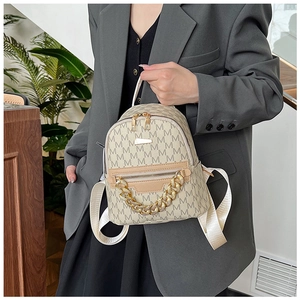 Detail of beige mini backpack with M-pattern print and chunky gold chain strap