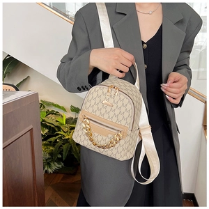 Detail of beige mini backpack with letter print, gold chain, and wide nylon shoulder strap