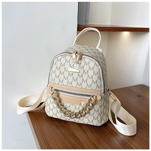 Detail of apricot mini backpack with M-letter print and decorative gold metal chain