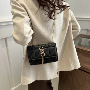 Sac minimaliste noir matelassé avec logo SS doré, pompon et bandoulière chaîne pour femme