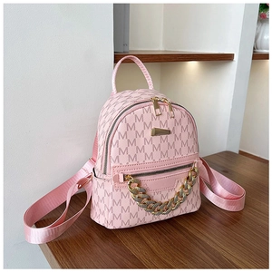 Pink PU leather mini backpack with gold chain detail and letter pattern on a wooden desk