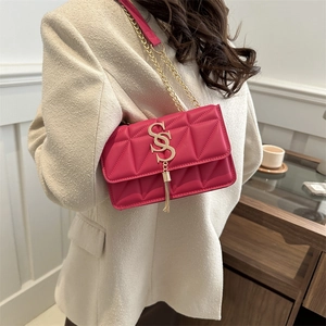 Sac à bandoulière matelassé rose fuchsia avec chaîne dorée et détail pompon élégant